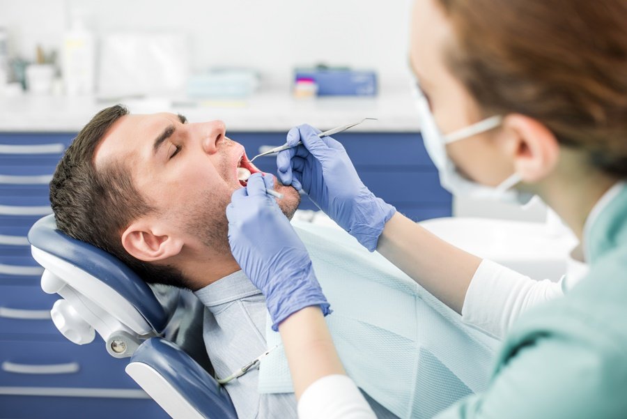 Odontólogo realizando revisión clínica para detectar sangrado de encías en consulta dental moderna