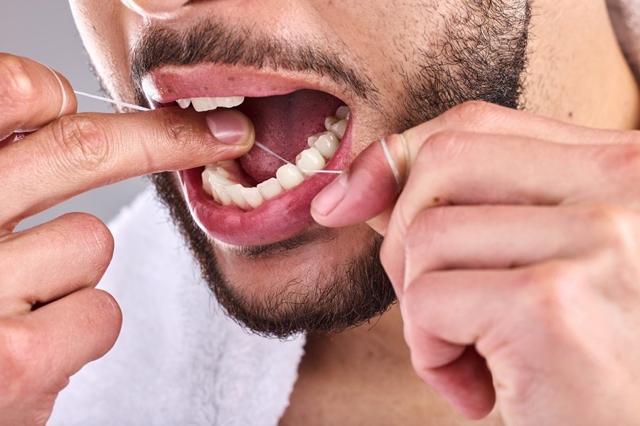 Uso correcto de hilo dental para prevenir el sangrado de encías y mejorar la higiene bucal diaria