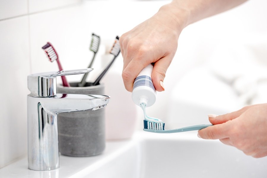 Aplicación de pasta dental sobre el cepillo como parte de la higiene bucal diaria, medida preventiva frente a la candidiasis oral.