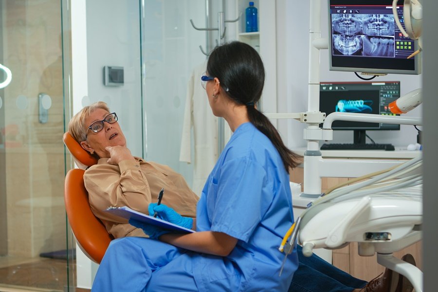 Paciente mayor consultando con profesional odontológico sobre molestias en la boca, síntomas asociados a la candidiasis oral.