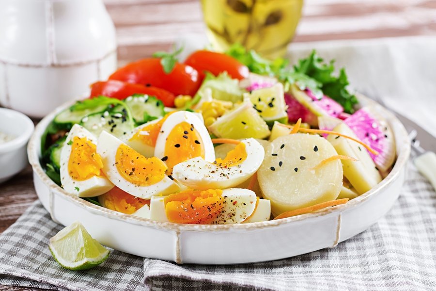 Plato equilibrado con huevos cocidos, verduras frescas y alimentos ricos en vitamina D y salud dental, esenciales para fortalecer dientes y encías.