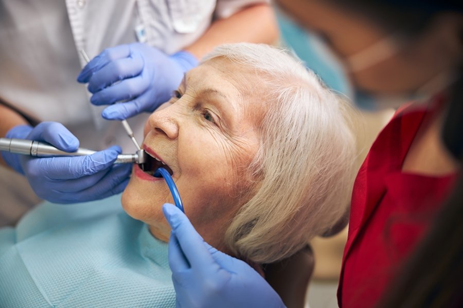 Mujer mayor recibiendo tratamiento odontológico profesional, una intervención clave en el abordaje de la caries radicular en adultos mayores.