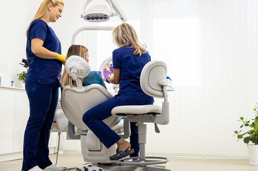 Dentistas evaluando a una paciente en gabinete dental, analizando posibles causas bucodentales relacionadas con ronquidos y salud dental.